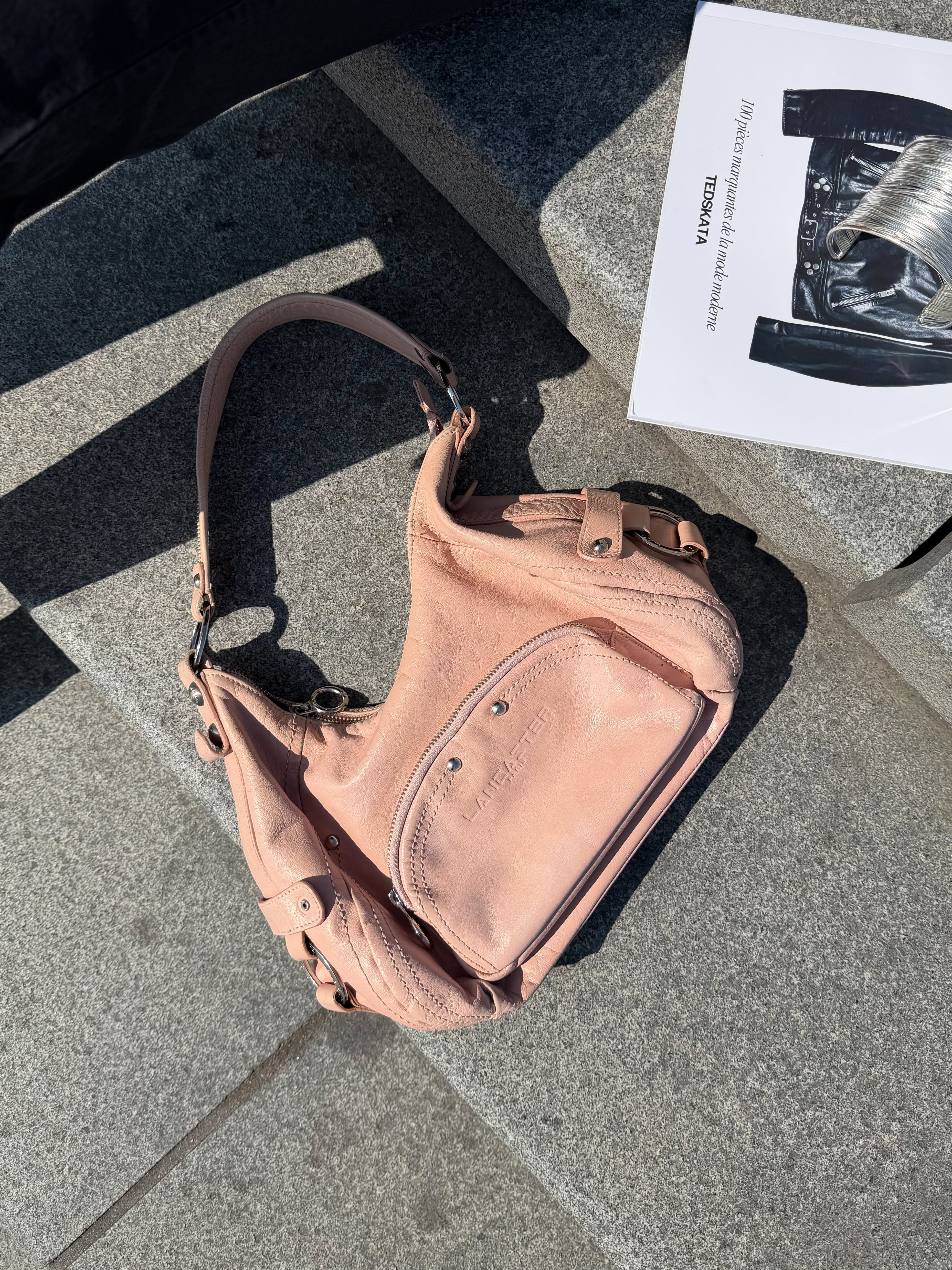 Mazette Vintage Club vous propose un sac en cuir rose pastel au style des années 2000. Pièce rare sélectionné pour son potentiel dans un dressing premium. 
Mazette est une friperie basée sur Paris et Bordeaux qui vous propose une séléction Y2K et de vintage intemporel. Cette pièce est disponible exclusivement sur le site internet www.mazettevintageclub.com à l’occasion du premier drop internet de la boutique.