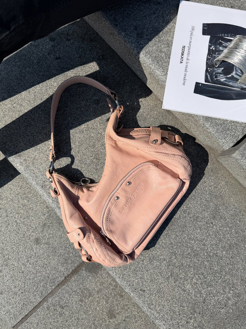 Mazette Vintage Club vous propose un sac en cuir rose pastel au style des années 2000. Pièce rare sélectionné pour son potentiel dans un dressing premium. 
Mazette est une friperie basée sur Paris et Bordeaux qui vous propose une séléction Y2K et de vintage intemporel. Cette pièce est disponible exclusivement sur le site internet www.mazettevintageclub.com à l’occasion du premier drop internet de la boutique.